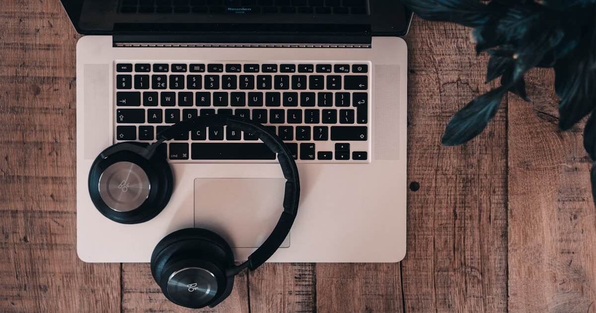 AliExpress Audio-Tracking 2026: Bluetooth-Kopfhörer auf einem Laptop als Sinnbild für unhörbares Fingerprinting