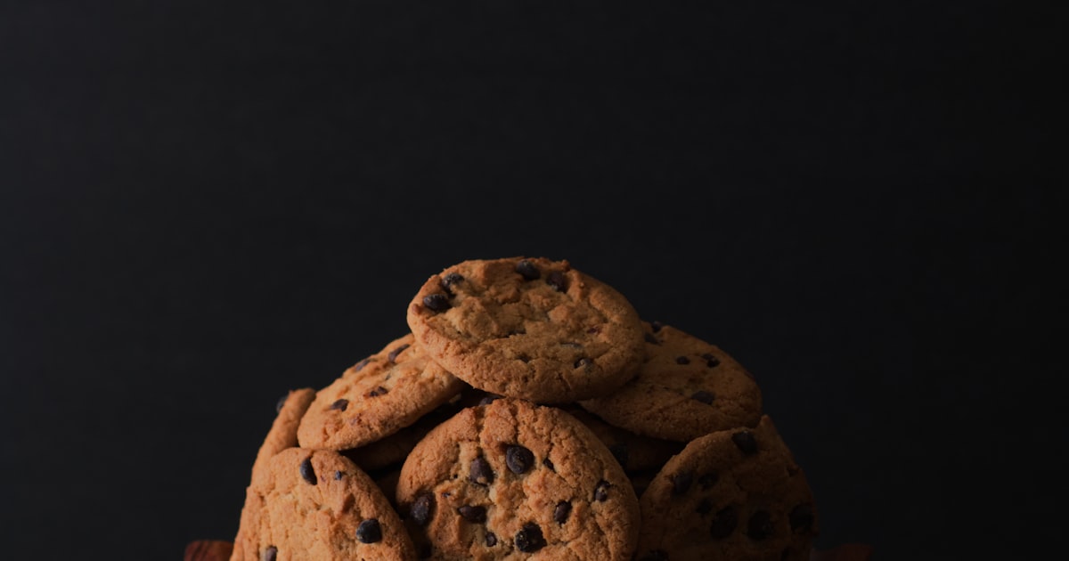 Cookie-Banner ablehnen und Tracking stoppen: Stapel Cookies vor dunklem Hintergrund als Sinnbild für Einwilligungsabfragen im Netz
