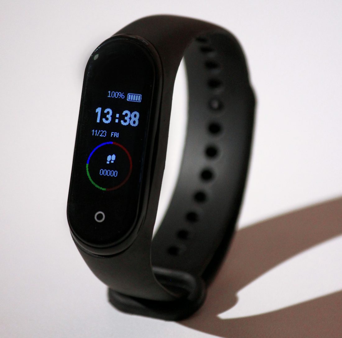 Gesundheitsdaten Apps Datenschutz: Fitness-Tracker am Handgelenk mit leuchtendem Display im Dunkeln