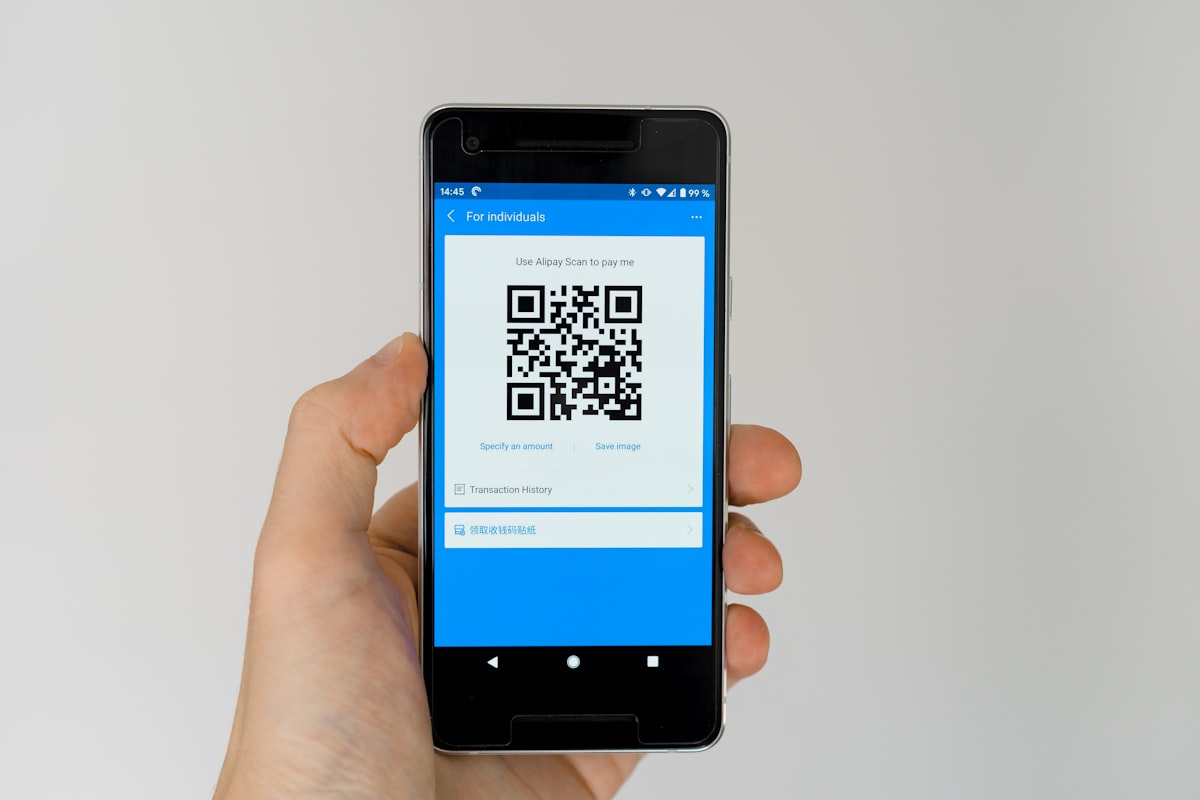 Person scannt einen QR-Code auf einem Restauranttisch mit dem Smartphone